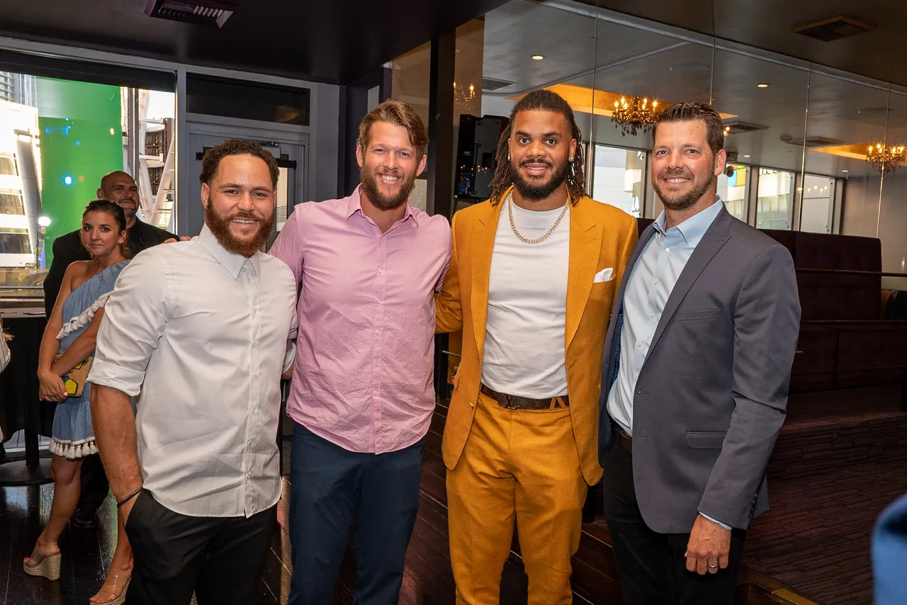 Four men posing together at an evening event