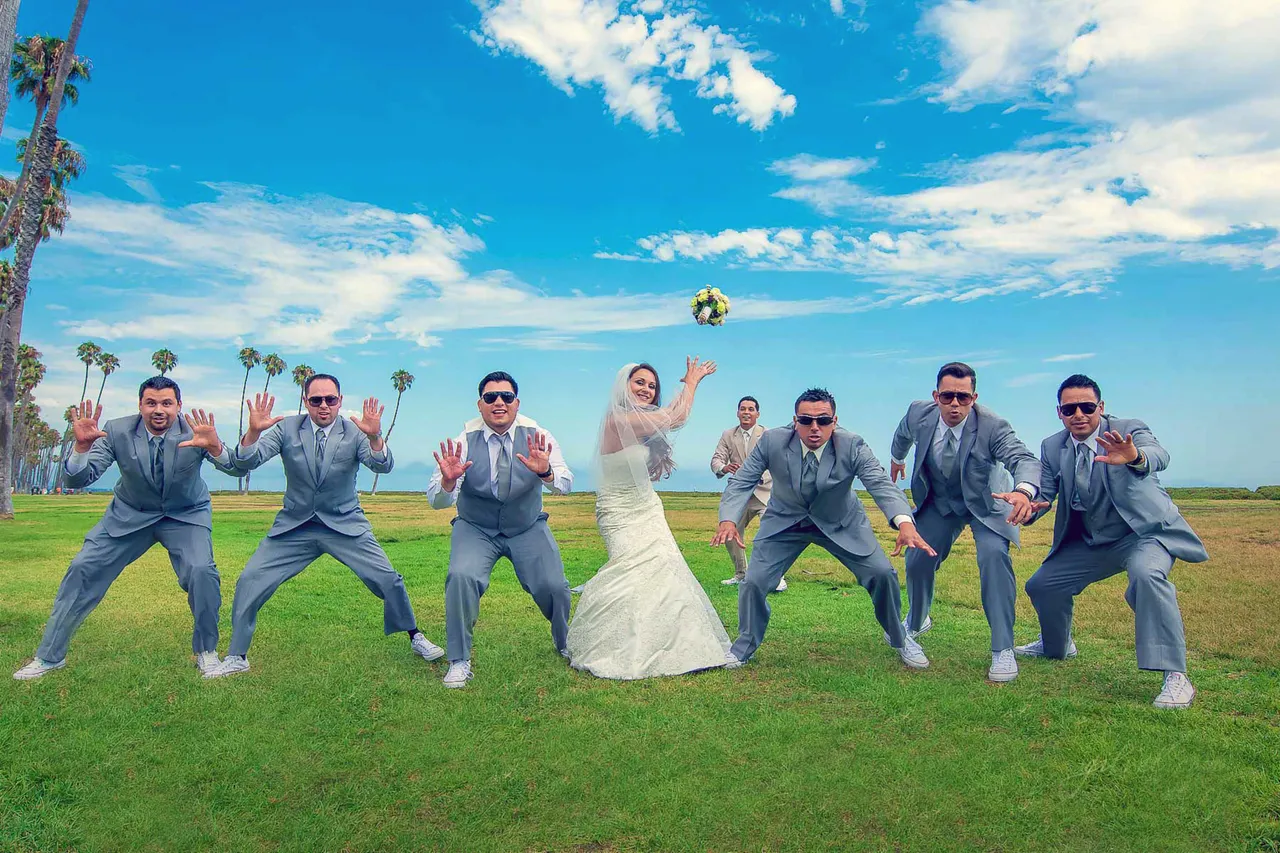 Bride tossing her bouquet with groomsmen reacting playfully in the background